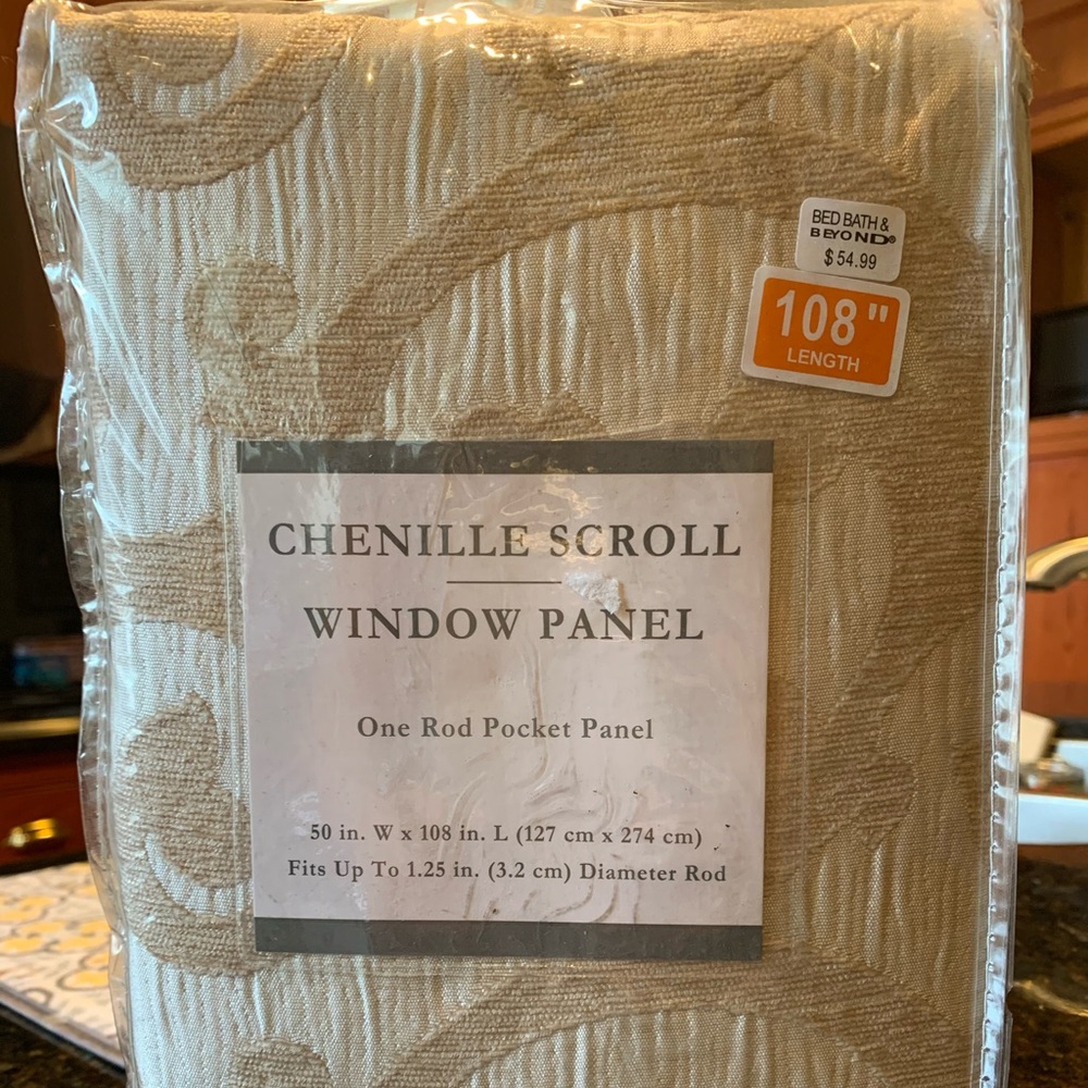2 Curtain panels 108” long; ivory scroll pattern.